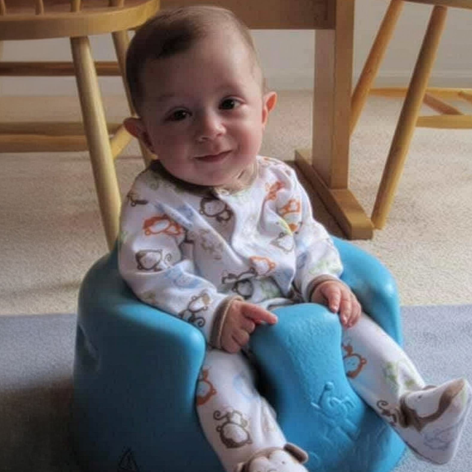 Baby Matthew Johns sitting and smiling, part of a Fragile X family featured in the Annual Appeal.